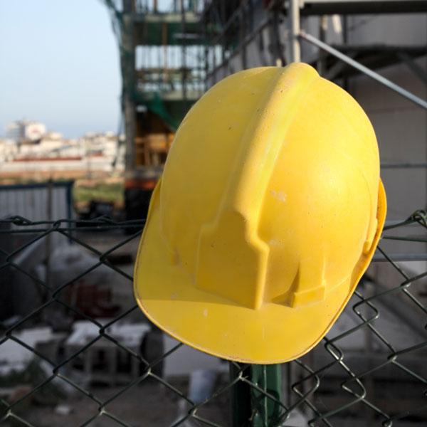 hard hat on fence at construction site